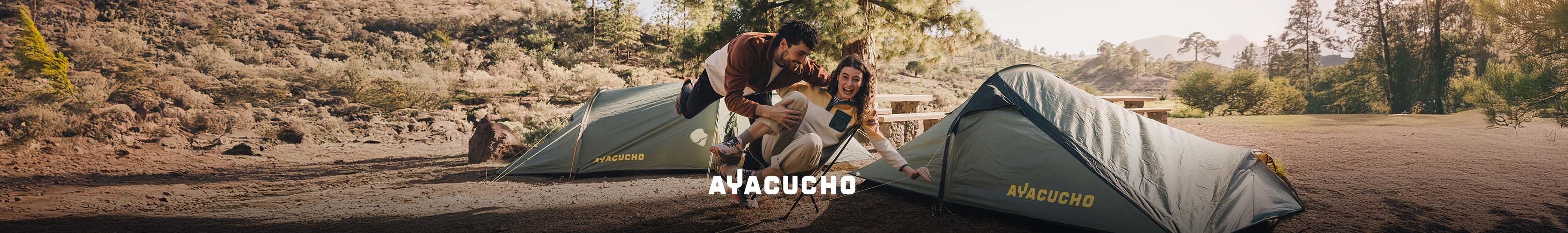 Ayacucho. man and woman sitting infront of 2 ayacucho tents