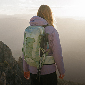 Man and woman hiking up a mountain wearing packs